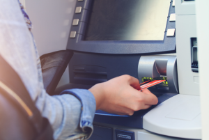 This picture is of a woman who is using an ATM.